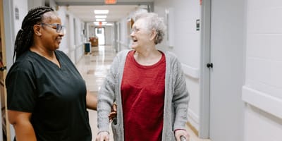 Staff assisting a resident in a hallway