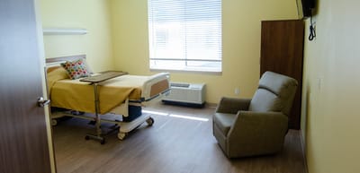 Private resident room with a bed and chair