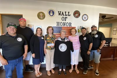 Residents and staff gather near the Wall of Honor