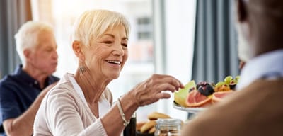 A senior woman enjoying food during a meal service