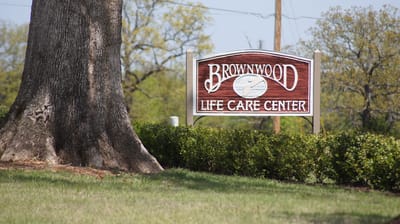 Sign of Brownwood Life Care Center outside in greenery