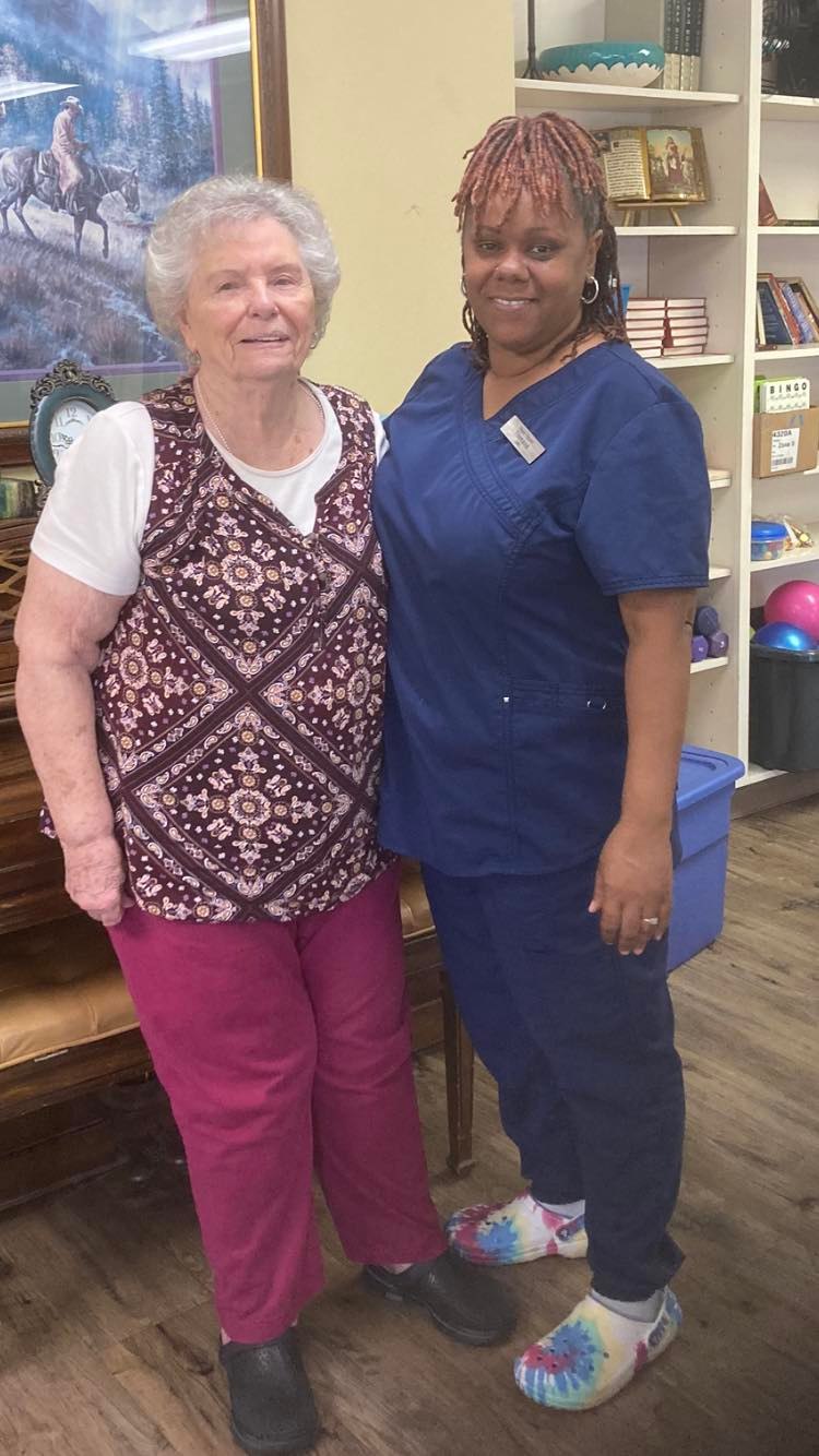 Resident and staff member smiling together in a common area