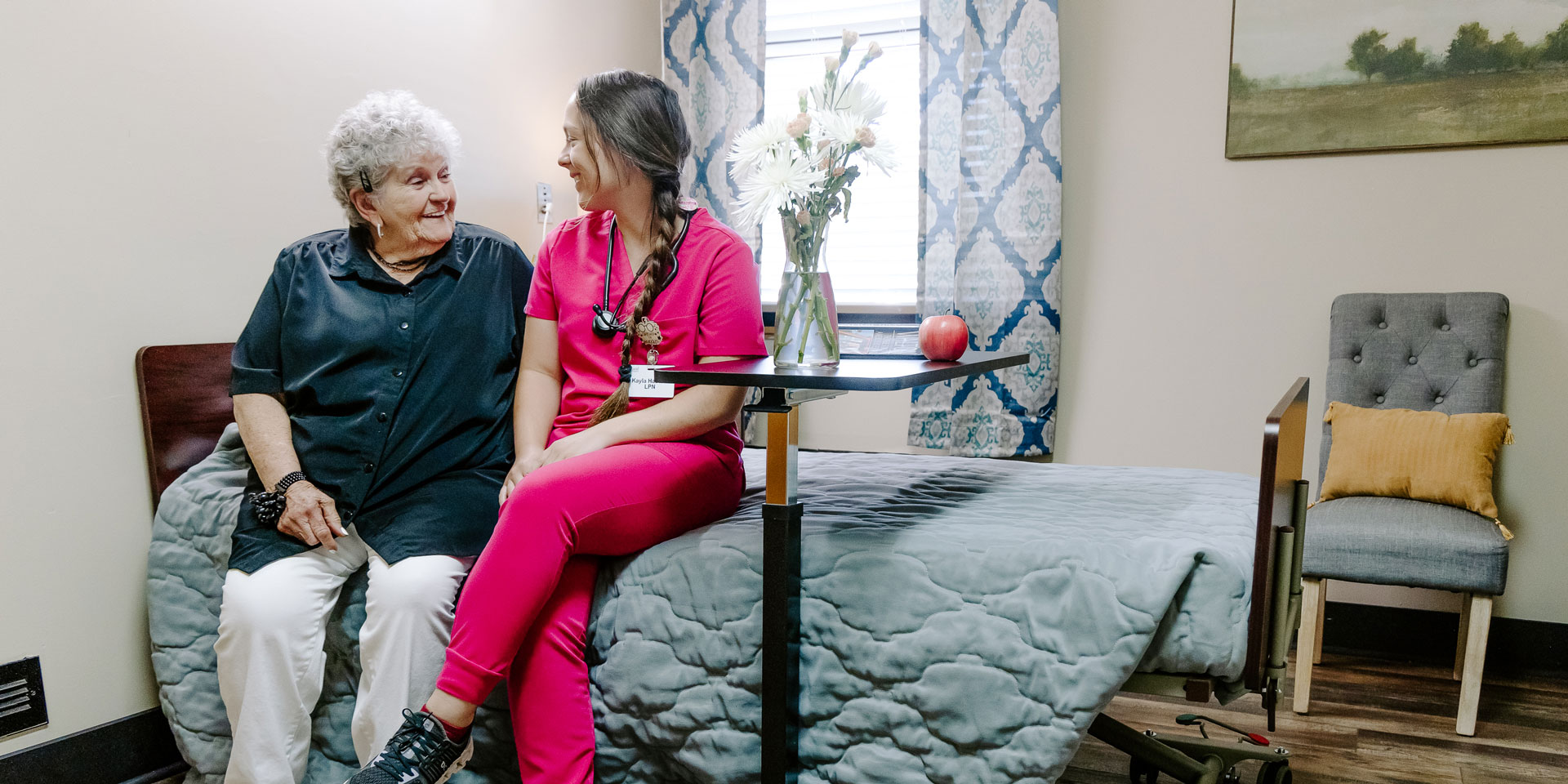 A resident and caregiver enjoying time together in a room