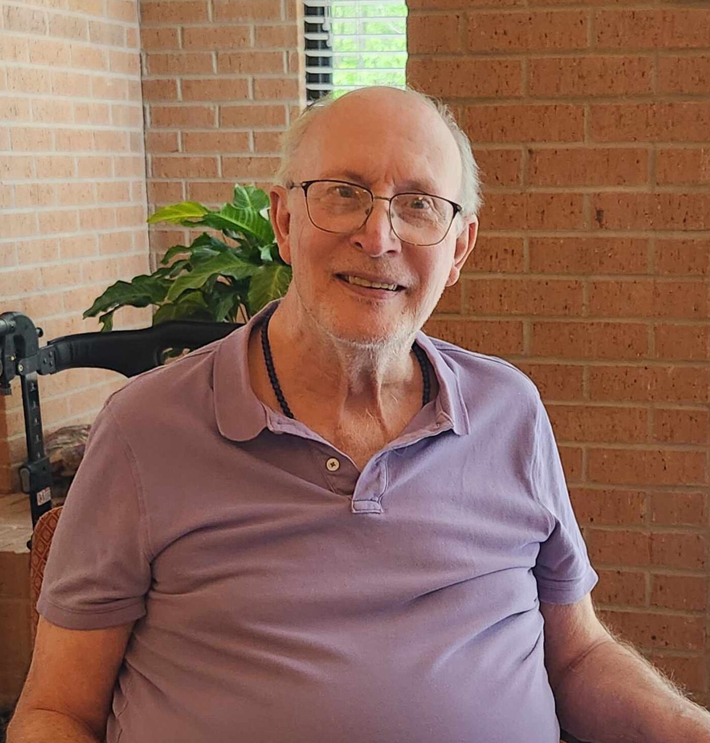 A senior man smiling in a well-lit interior
