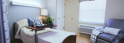 A cozy resident room with a bed and seating area