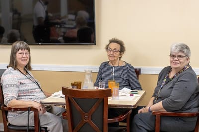 Three residents enjoying a meal together in the dining area
