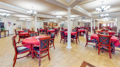 Dining area with red tablecloths and decorative chandeliers