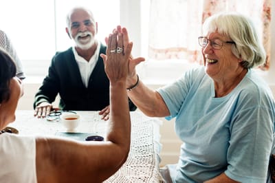 Autumn Ridge Residences, assisted living in Herculaneum, MO — Seniors sharing laughter during a game at a table