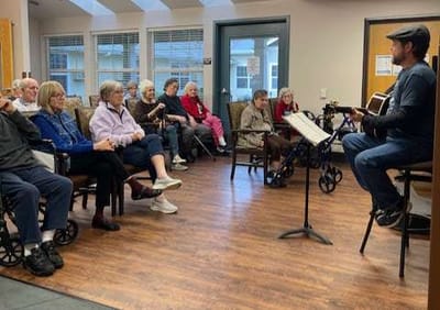 Residents enjoying a musical performance in a common area