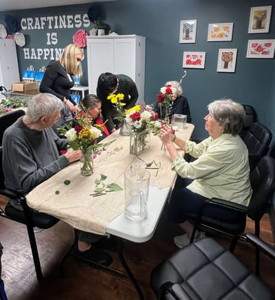 Residents creating flower arrangements in an activity room