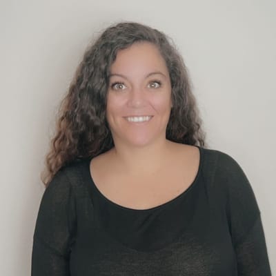 Smiling woman with curly hair in a black top