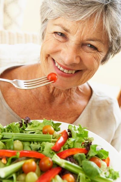Smiling senior woman enjoying a healthy salad
