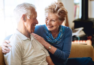 A woman smiling while interacting with a man in an indoor setting