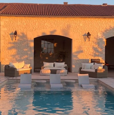Outdoor pool area with lounge seating and stone walls
