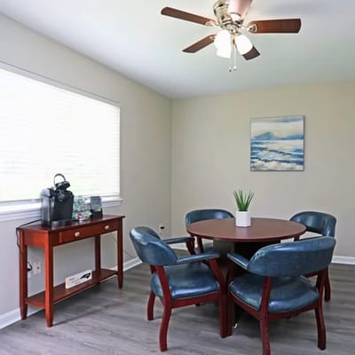 A brightly lit interior dining area with chairs and a table