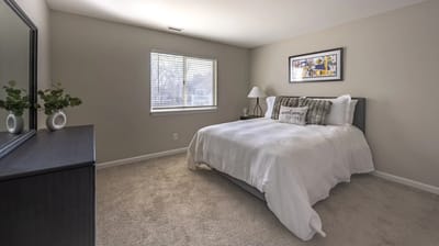 A bright resident room with a cozy bed and window
