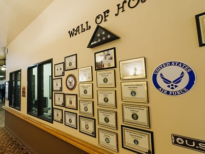 A wall displaying various military service certificates and honors