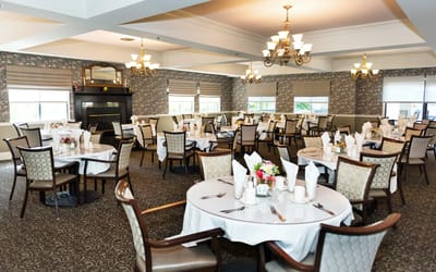 Dining room set up for a meal with tables and chairs