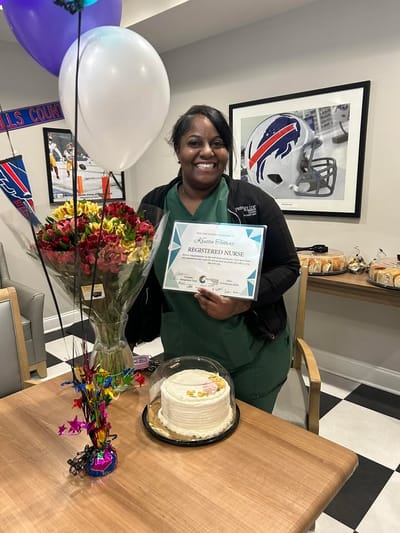Nurse celebrating with cake and flowers in common area