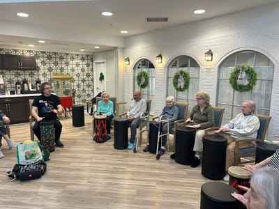 Residents participating in a drumming activity in a common area