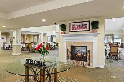 Bright dining area with a fireplace and floral arrangements