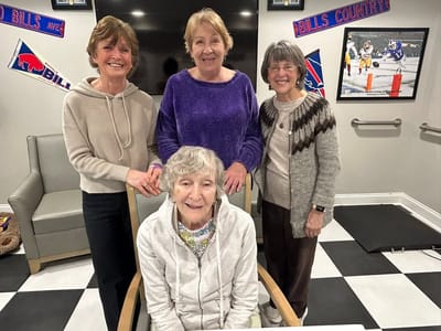 Residents and staff smiling together in a common area