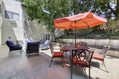 Outdoor seating area with a red umbrella and chairs