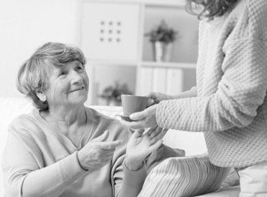 Orchards Assisted Living, assisted living in Medford, OR — Senior woman receiving a cup of tea from caregiver