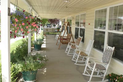 Covered porch with rocking chairs and hanging flowers