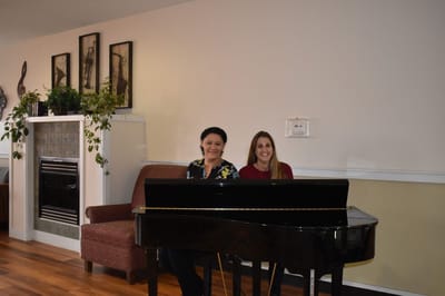 Orchards Assisted Living, assisted living in Medford, OR — Two women seated at a piano in a lounge area