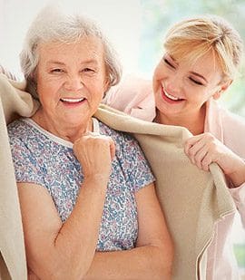 Orchards Assisted Living, assisted living in Medford, OR — Smiling senior woman being assisted by a caregiver
