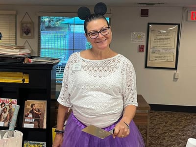 Staff member in costume with a spatula in a common area