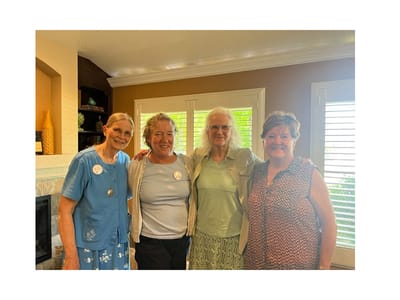 Four residents smiling together in a common area