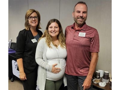 Three staff members posing at an event