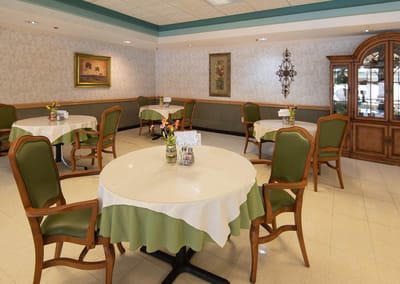 Dining room area with tables and green chairs