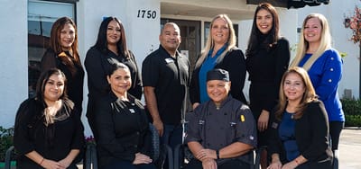 Staff members posing outside the facility entrance