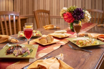 A beautifully set dining table with meals and drinks.