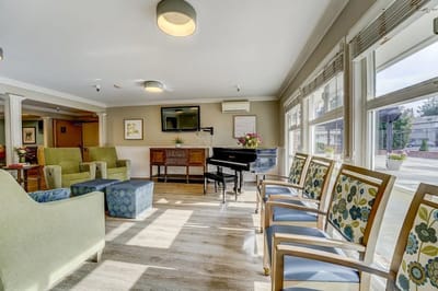 Bright common area with seating and a piano