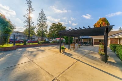 Outdoor patio area with shaded seating and gardens