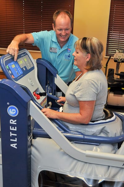 Staff assisting a resident with therapy equipment