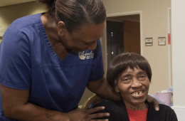 Magnolia Manor of Marion County, Nursing Home in Buena Vista, GA — Caregiver assisting a resident in a cheerful setting