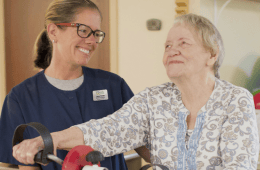 Magnolia Manor of Marion County, Nursing Home in Buena Vista, GA — Staff member assisting a smiling senior resident