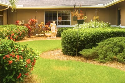 Well-maintained garden area with colorful flowers and a statue