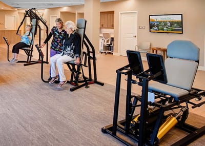 Residents participating in exercise activities with staff assistance