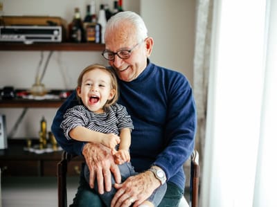 Elderly man enjoying time with a child in a cozy living room
