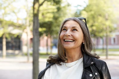 A smiling woman enjoying a sunny outdoor area