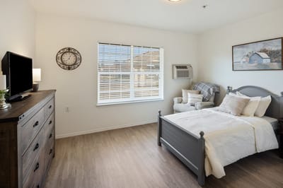 Cozy private resident room with a bed and chair
