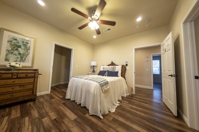 Brightly lit resident room with a bed and dresser