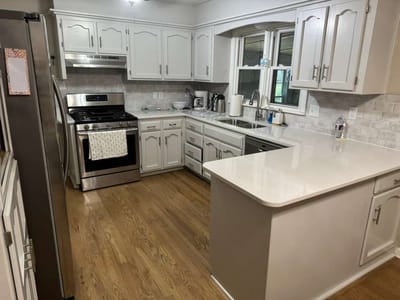 Bright kitchen area with modern appliances and wood floors