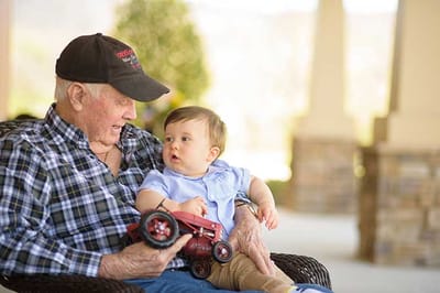 An elderly man with a young child outdoors